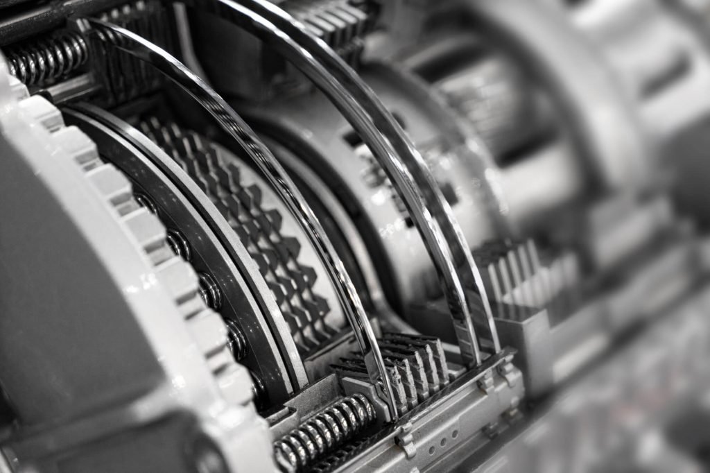A monochromatic close-up of an automatic gearbox's internal multi-plate clutch packs and return springs