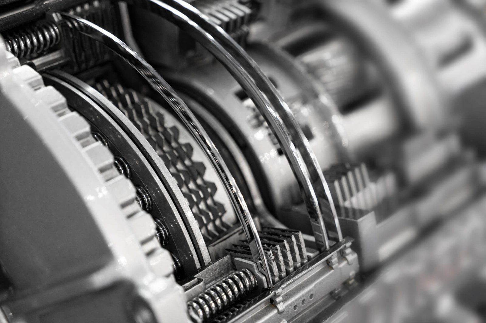 A monochromatic close-up of an automatic gearbox's internal multi-plate clutch packs and return springs