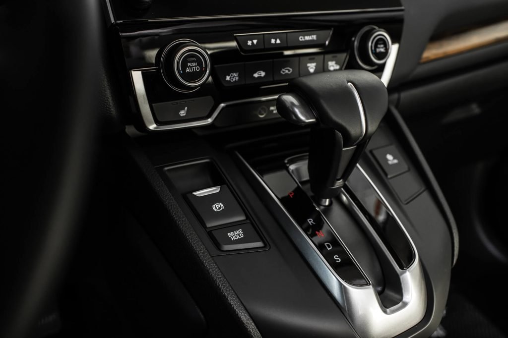 A close-up of a sleek, modern vehicle dashboard featuring an automatic gear selector in the "P" (Park) position, with digital displays.